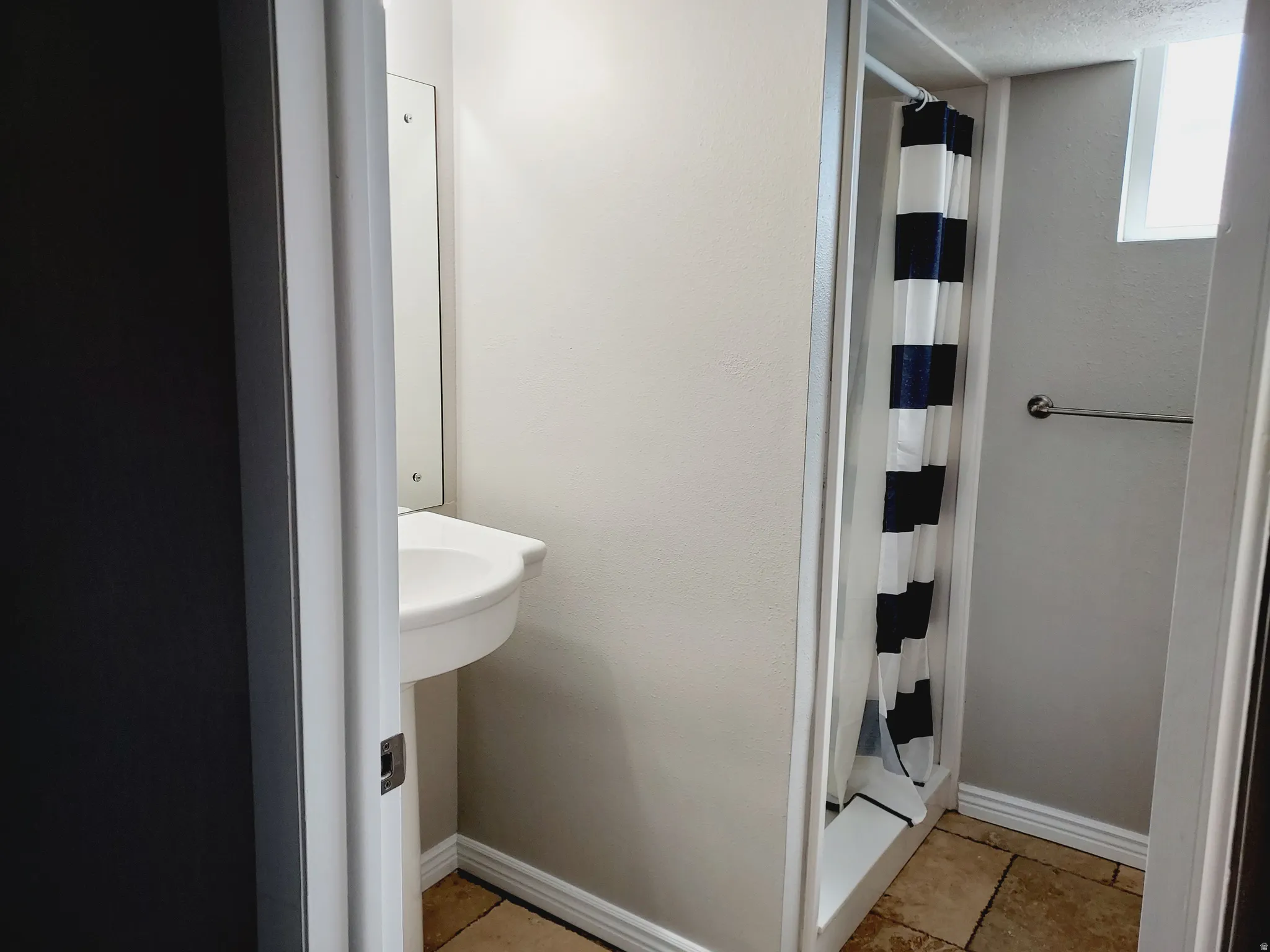 Full bathroom with a stall shower and baseboards
