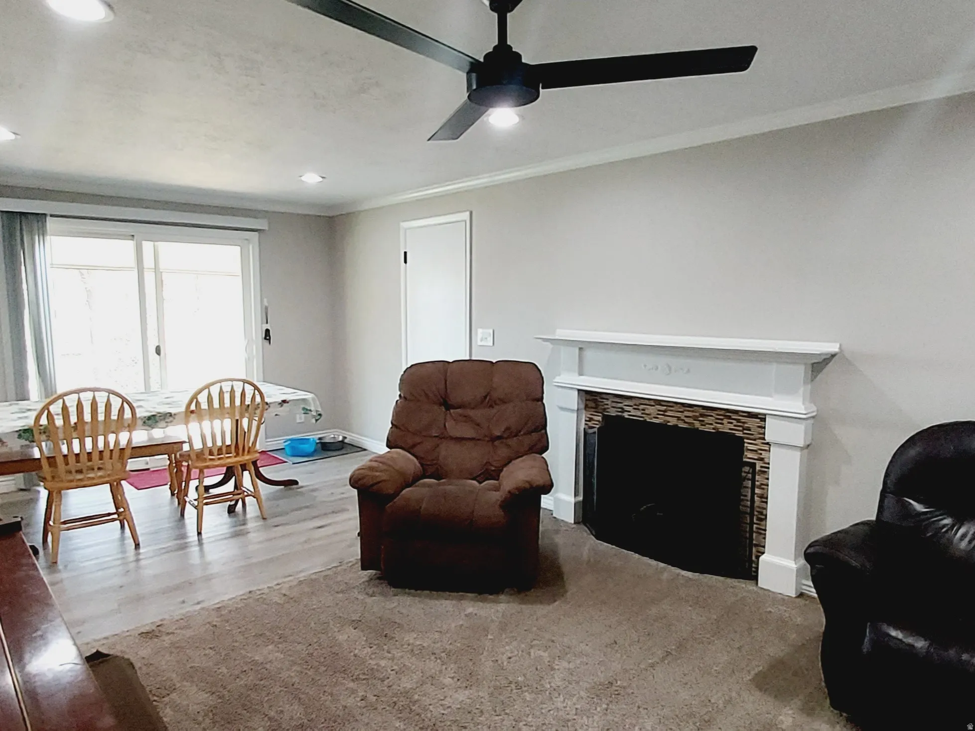Living area with ornamental molding, a fireplace, recessed lighting, ceiling fan.
