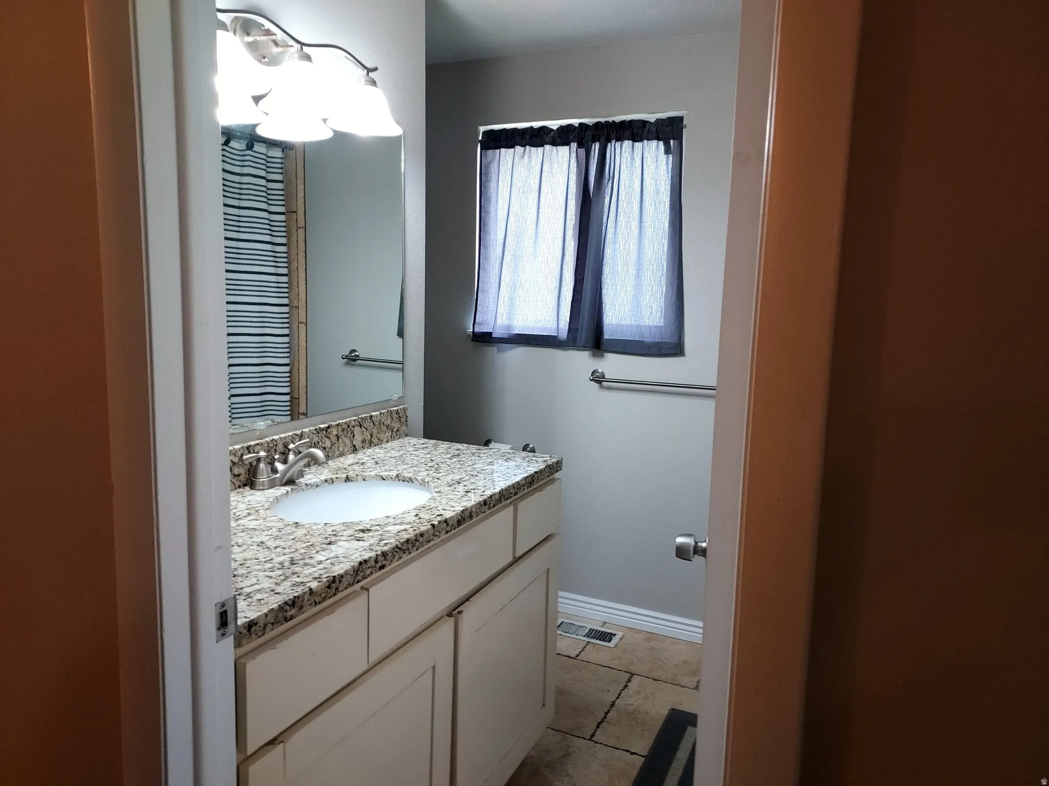 Half bathroom featuring vanity and baseboards