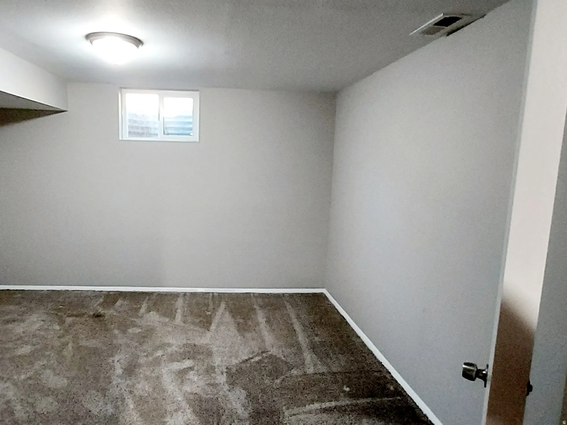 Basement with carpet floors and a textured ceiling