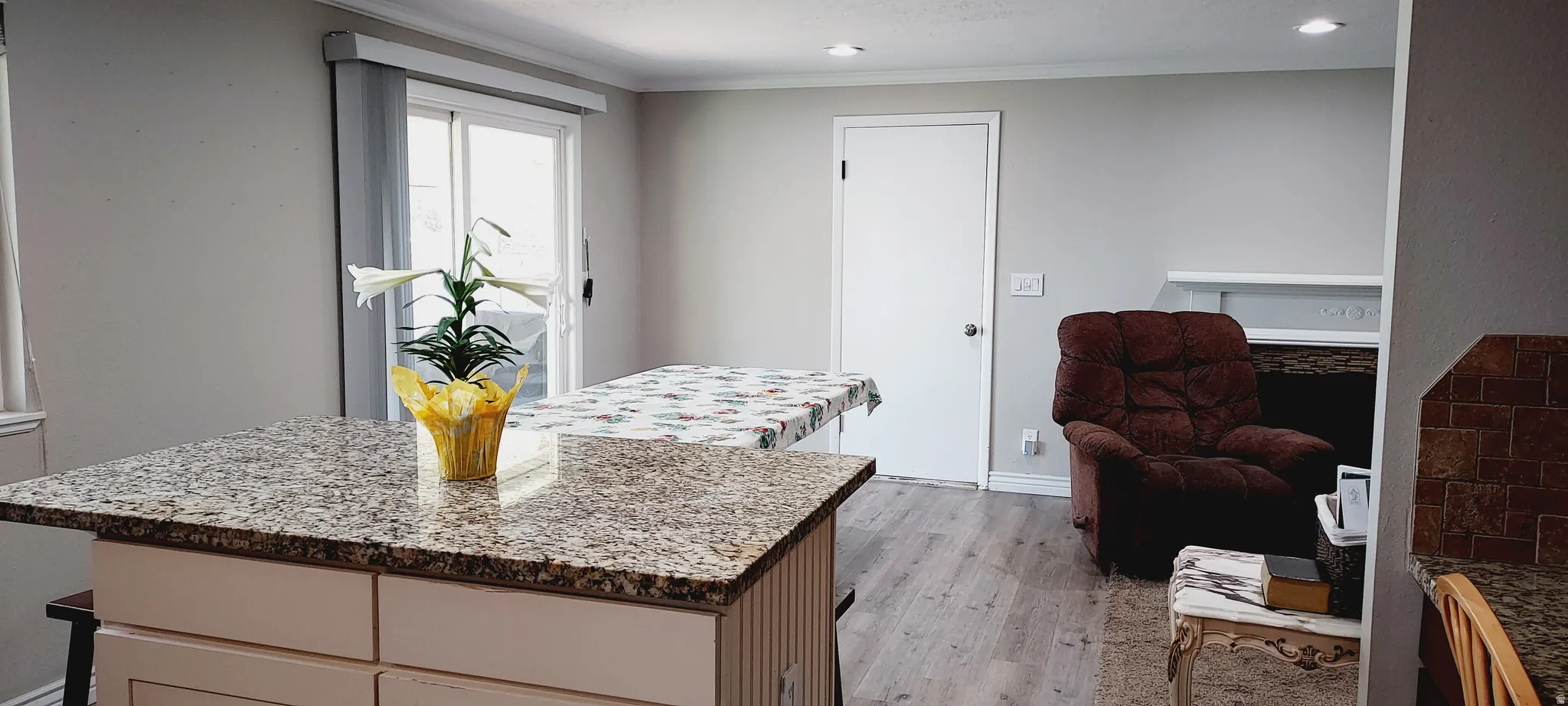 Kitchen featuring a kitchen island, light stone countertops, crown molding, and recessed lighting