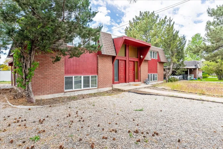 Brick and vertical panel exterior with a prominent red double-door entry
