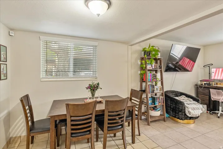 Dining area featuring a window with blinds, a ceiling-mounted light fixture, and tile flooring