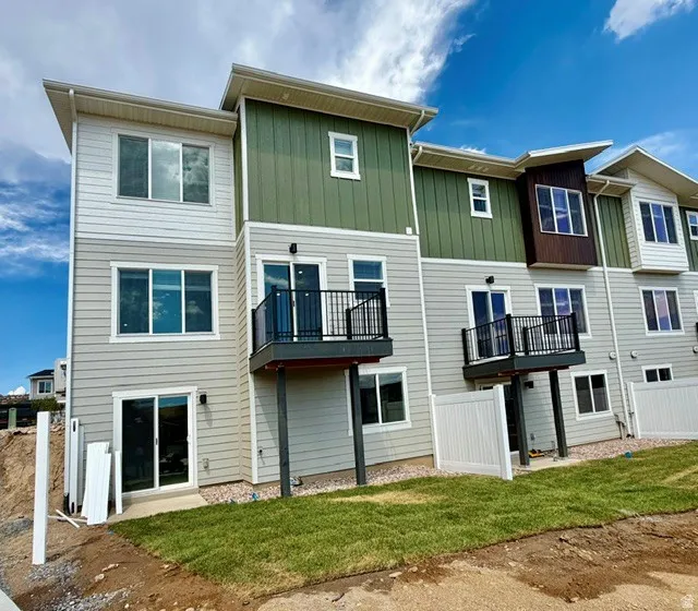 Modern multi-level exterior featuring light gray and green siding