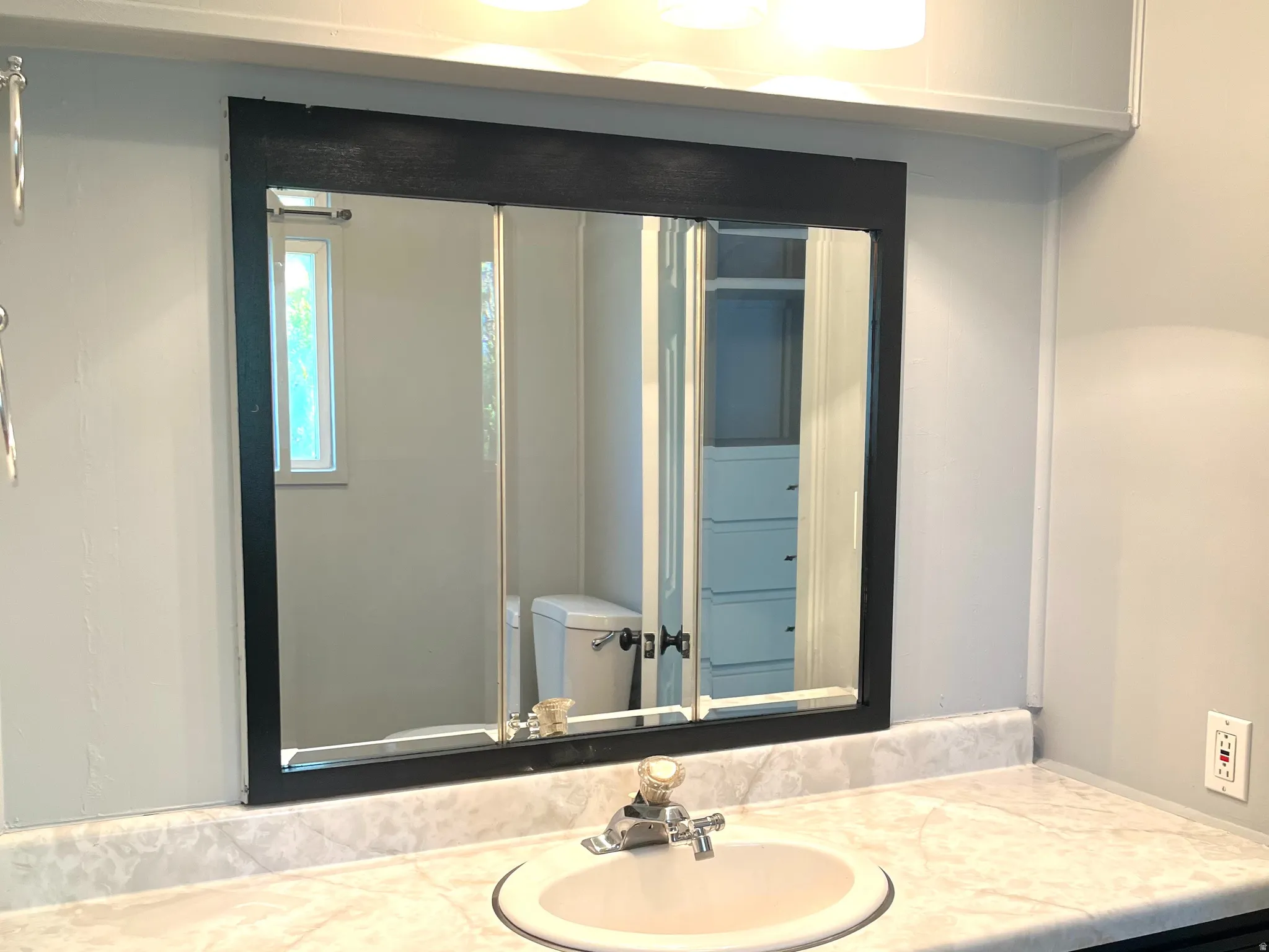 Vanity with an integrated sink, polished chrome faucet, and a patterned countertop