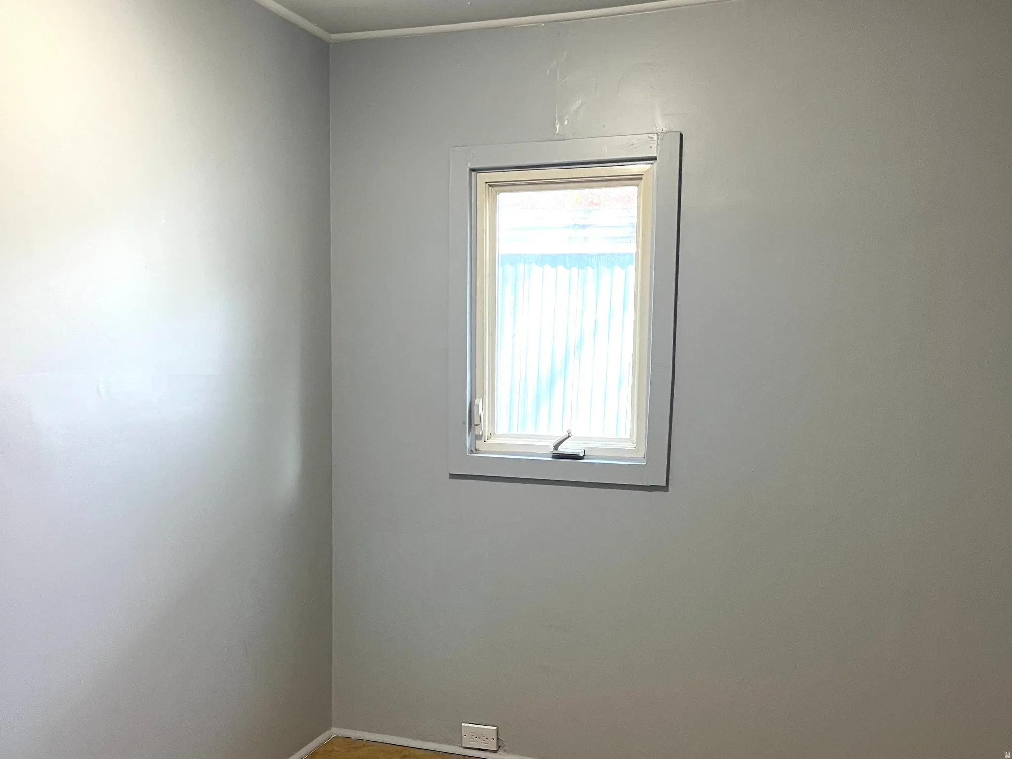 Light gray walls complemented by a single window with a white frame