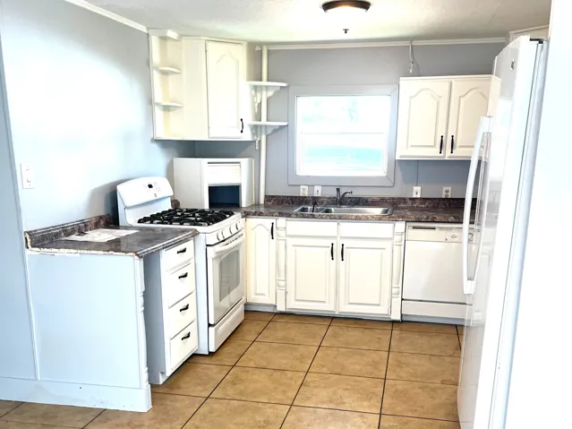 Kitchen featuring white cabinetry, stone-finish countertops, and a tile floor