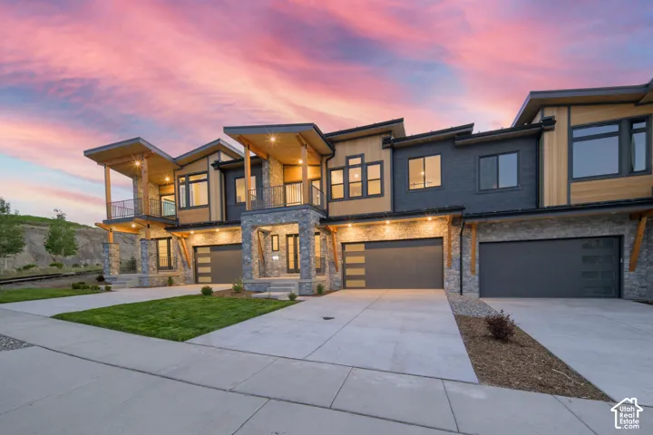 Contemporary multi-level townhome exteriors featuring stone accents, wood siding, and dark paneling