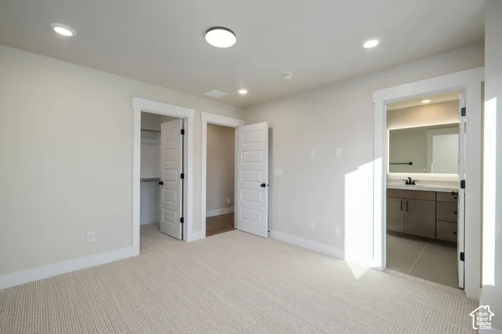Carpeted room with recessed lighting and neutral wall tones