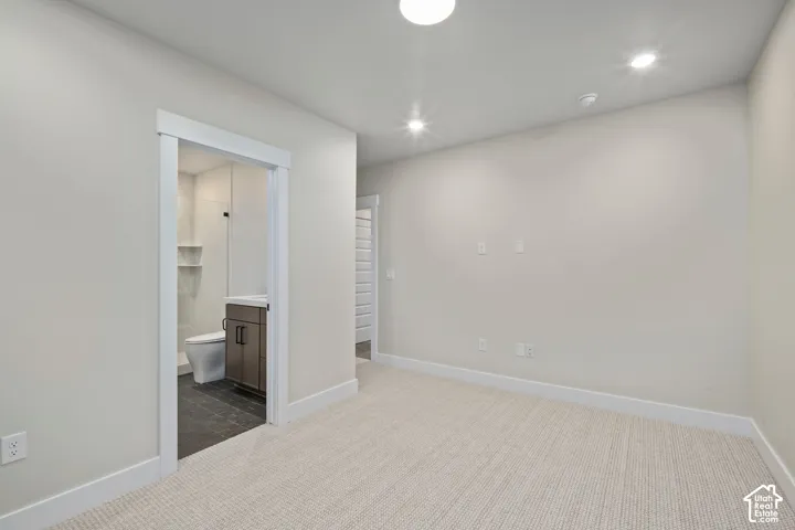 Carpeted room with recessed lighting and neutral wall tones