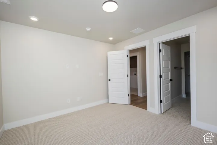 Carpeted room featuring multiple entryways with white trim and five-panel doors