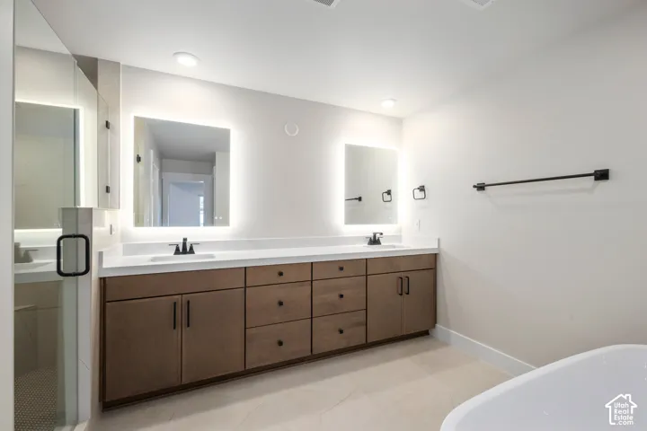 Double vanity with wood-finish cabinetry, white countertops, and integrated sinks