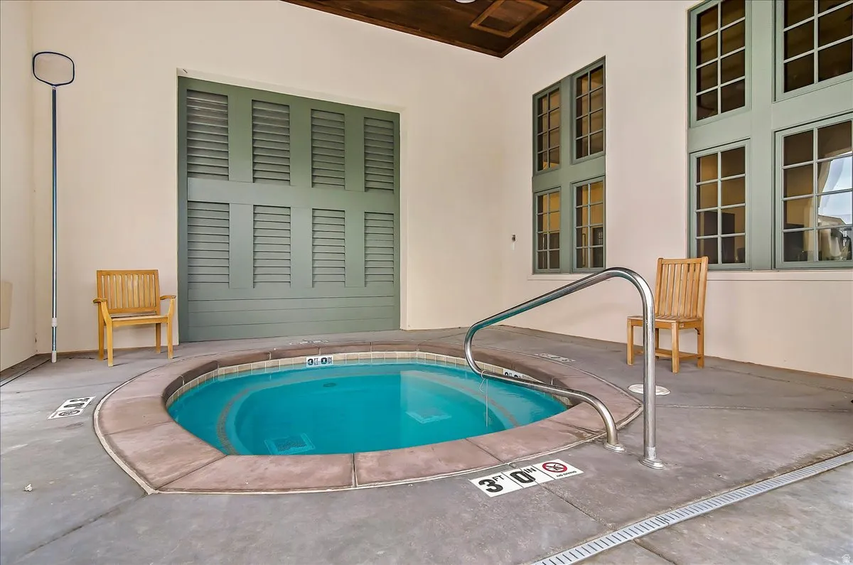 Built-in circular spa with concrete coping and a stainless steel grab rail