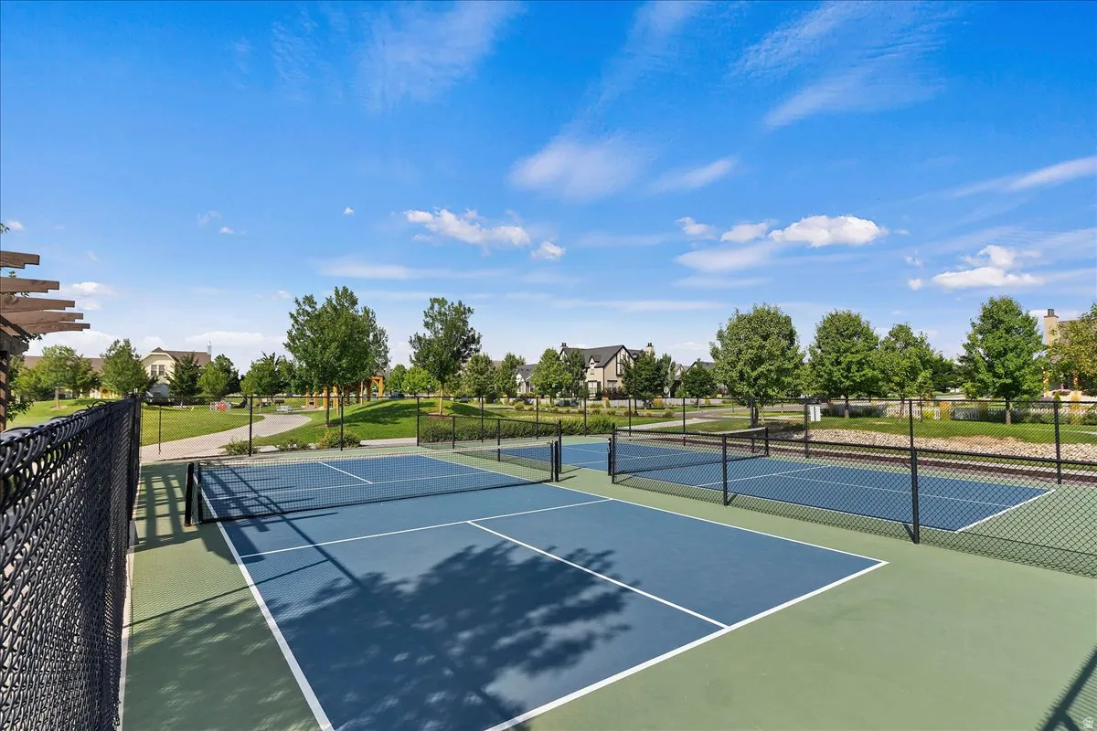 Recreational courts featuring two blue-surfaced tennis courts, two blue-surfaced pickleball courts, and black chain-link fencing