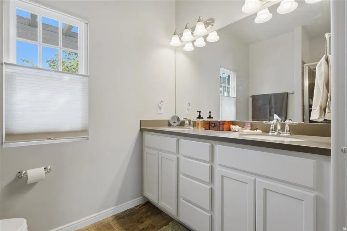 Double vanity with white cabinetry, light countertops, and under-mount sinks