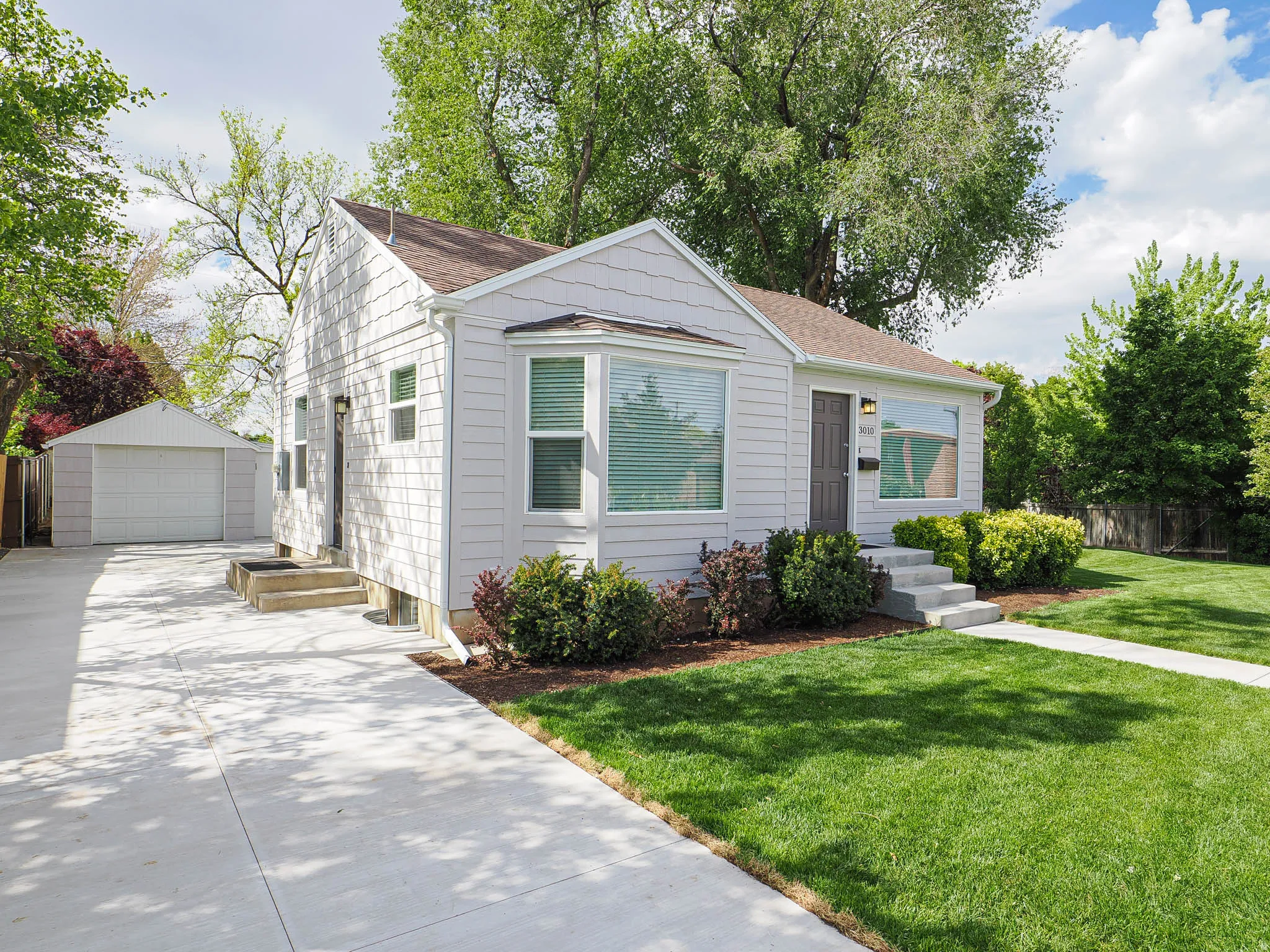 Exterior with light-toned shingle siding and a bay window
