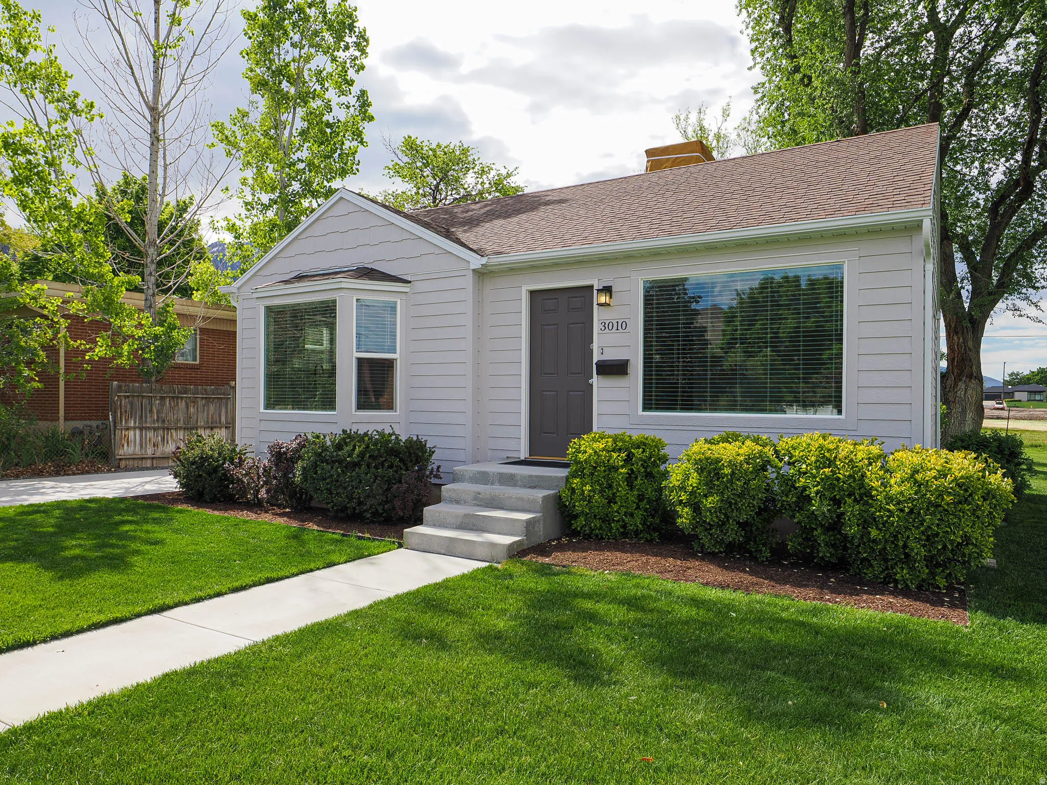 Light gray siding exterior with a dark brown front door and white trim