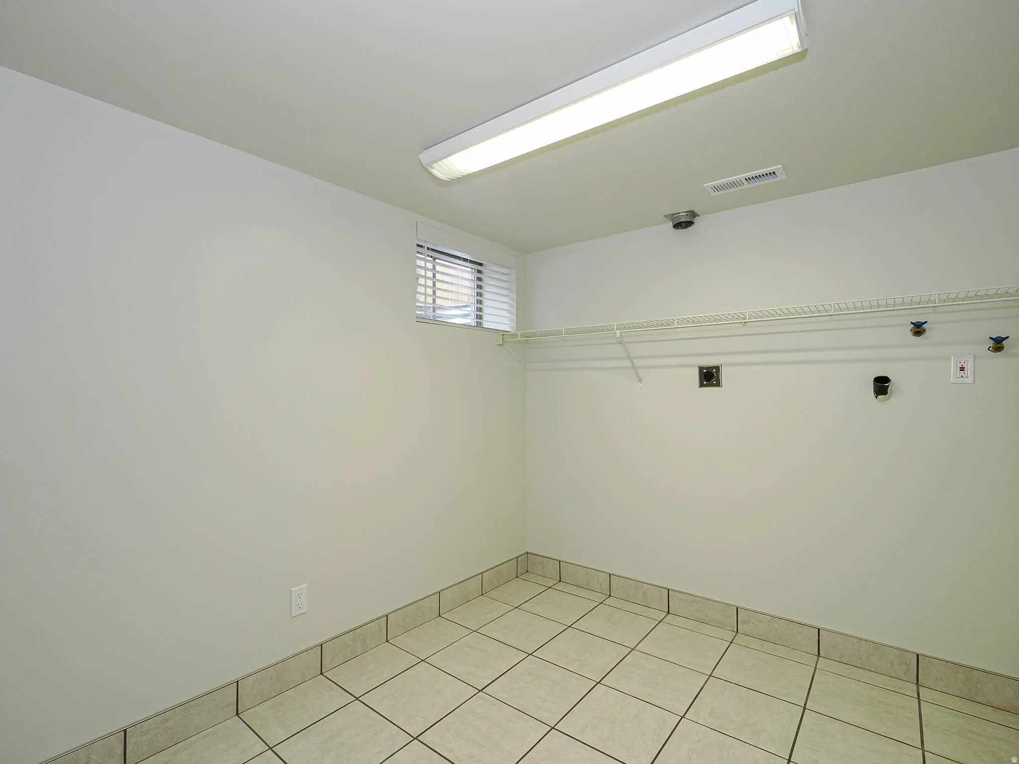 Utility room & laundry featuring ceramic tile flooring, a window with horizontal blinds, built-in wire shelving, LED lighting.