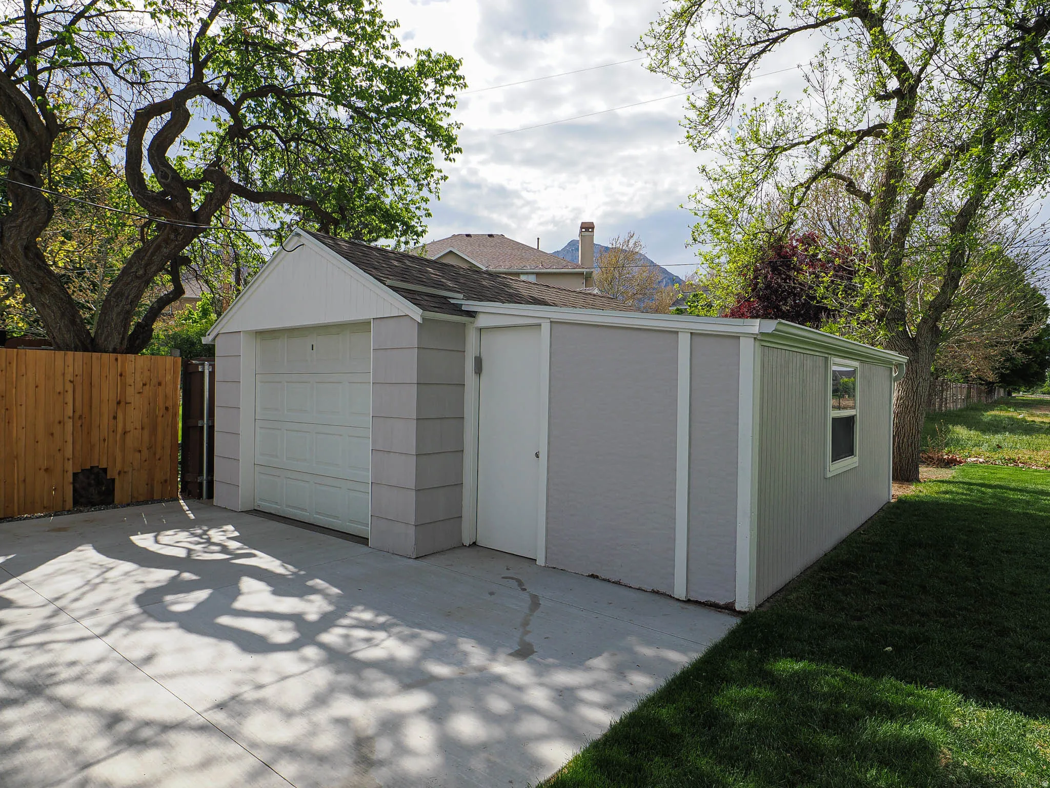 Detached garage structure featuring a single garage door, side entrance, and an additional window