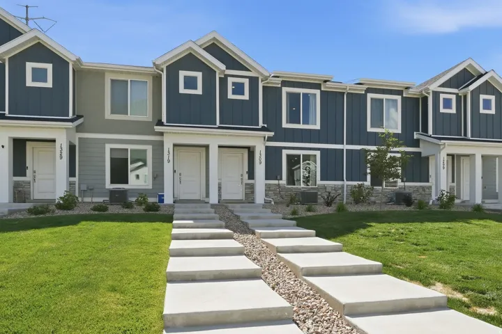Contemporary townhome-style residences featuring a multi-tone exterior with dark blue siding and light grey accents