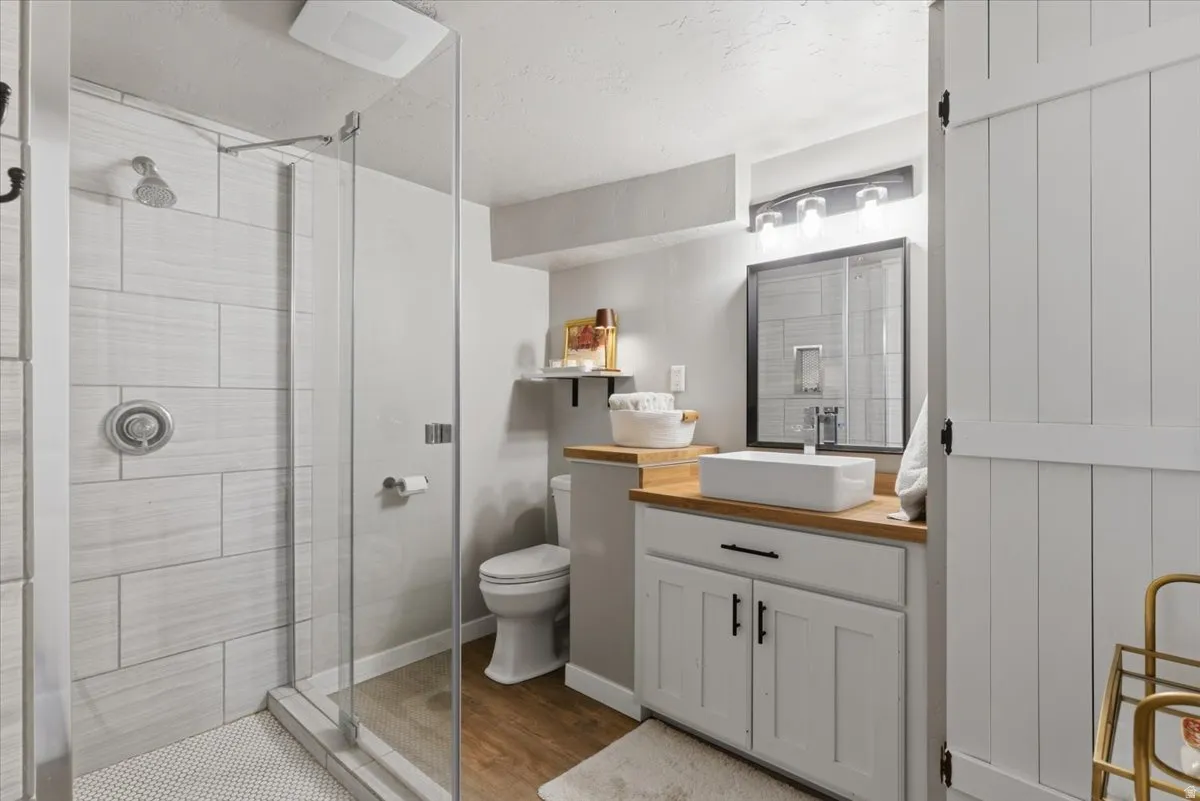 Bathroom featuring a glass-enclosed shower with subway tile surround and mosaic tile flooring