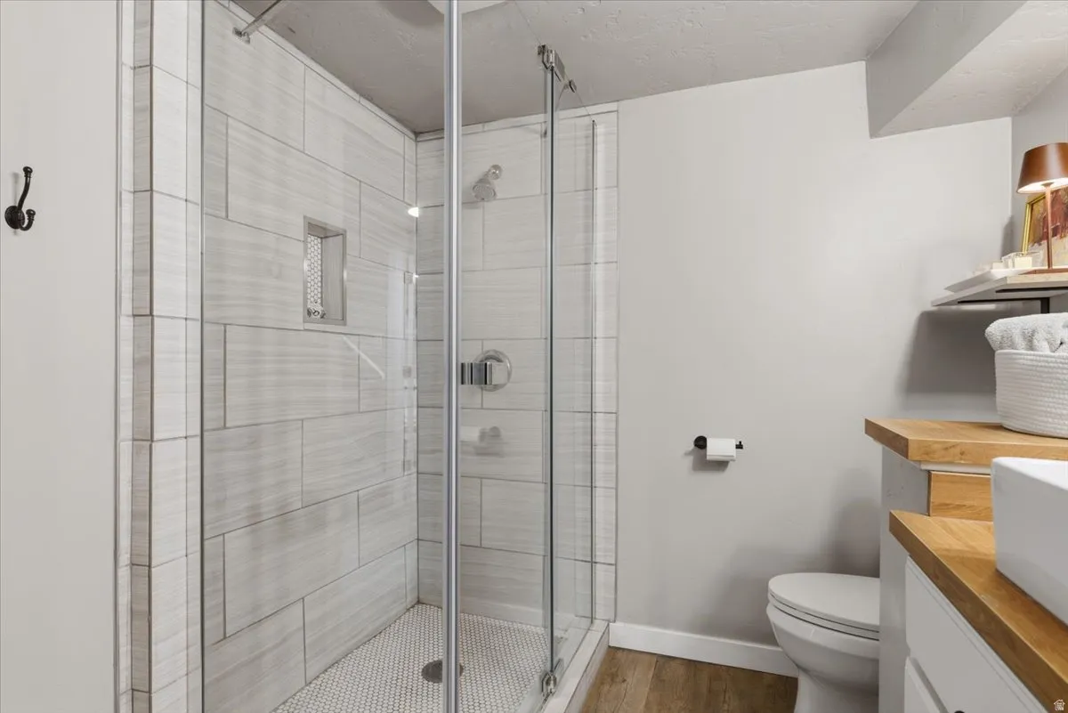 Modern bathroom featuring a glass-enclosed shower with subway tile surround and mosaic floor