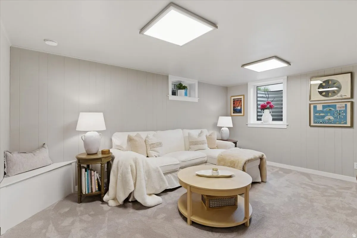 Carpeted recreation room featuring light gray vertical paneling
