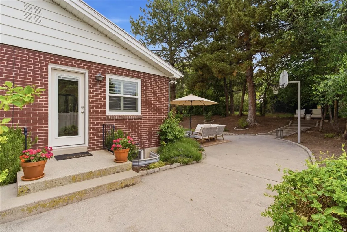 Red brick exterior with white trim and a concrete patio