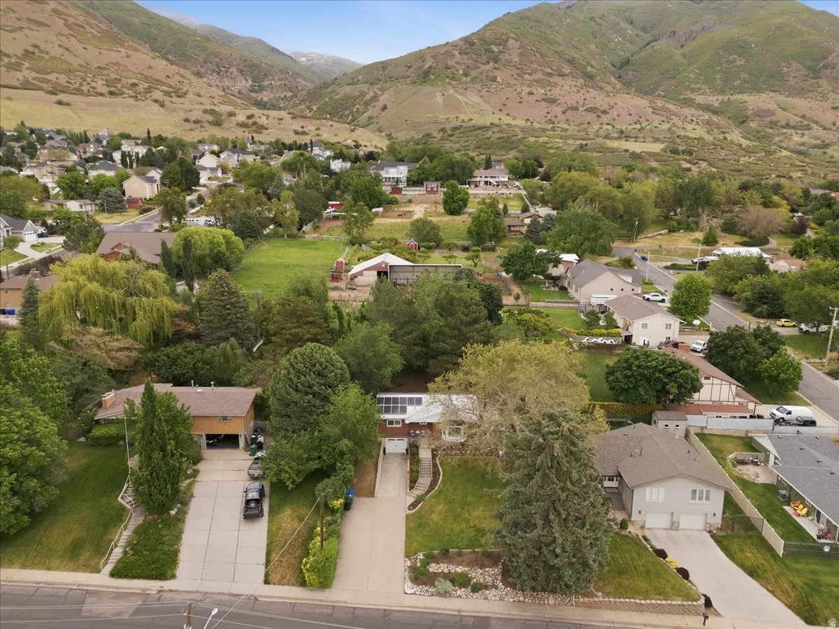 Aerial perspective showcasing residential properties nestled at the base of a verdant mountain range