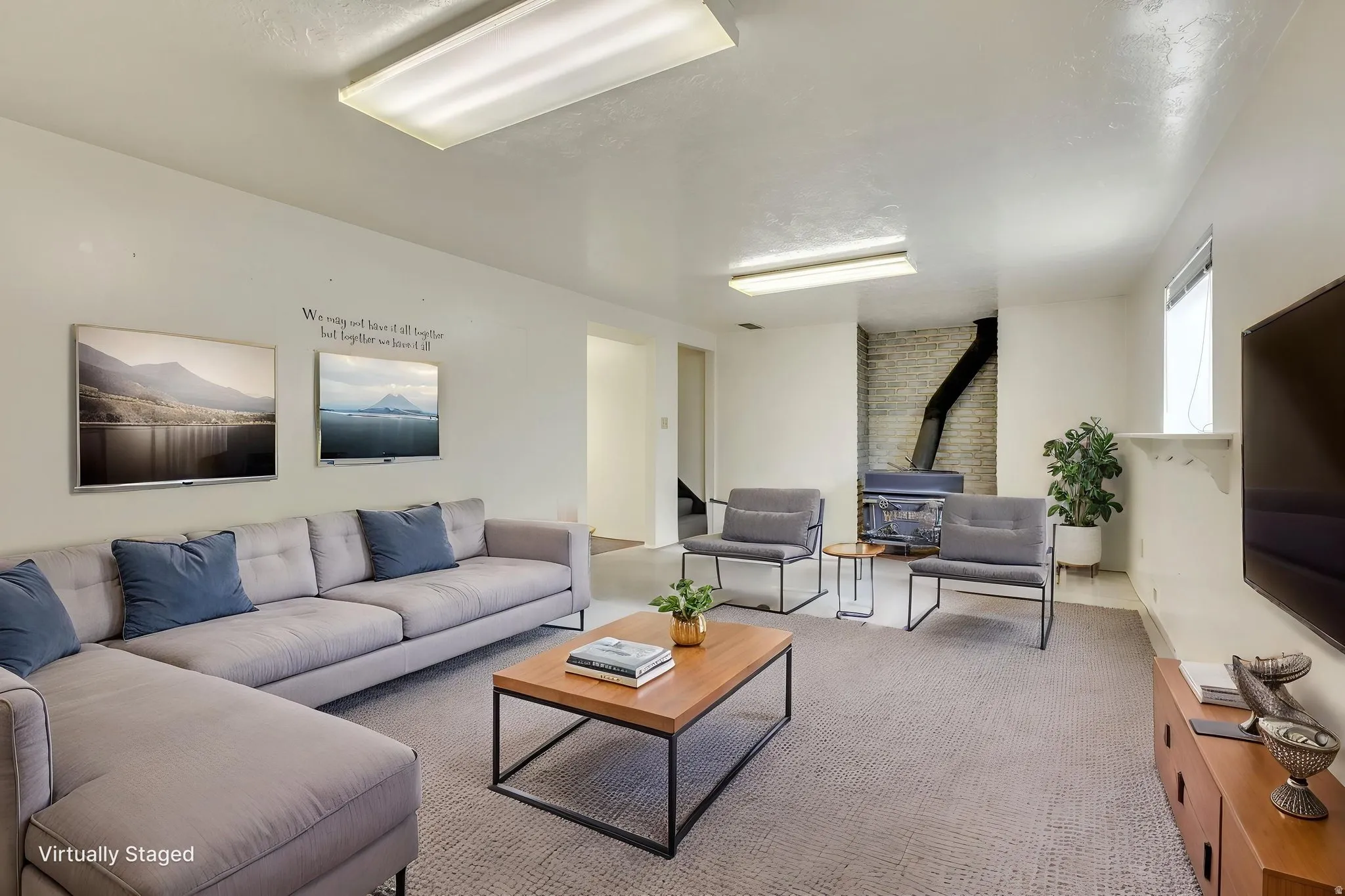 Virtually Staged -Spacious living area featuring a built-in wood-burning stove, exposed brick chimney, and ample wall space