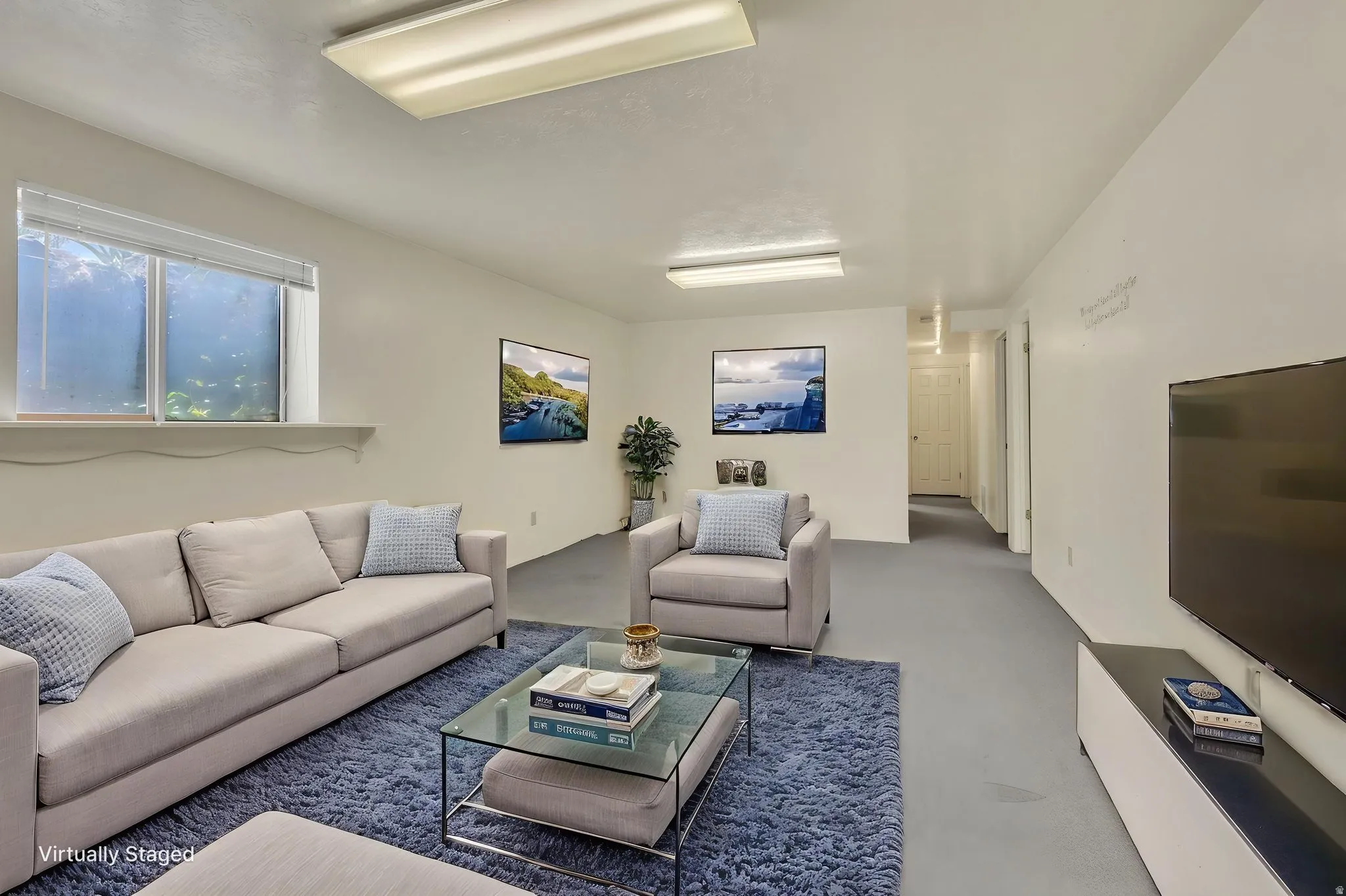 Virtually Staged -Spacious recreation room featuring light-colored walls, recessed window, and gray flooring