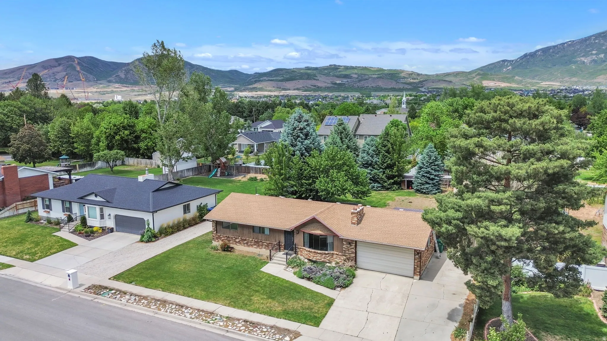 Single-story residence featuring a classic brown shingle roof, stone facade accents, and an attached two-car garage