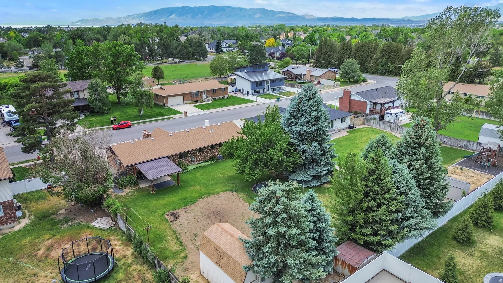 Expansive property featuring mature trees, a detached storage shed, and mountain scenery