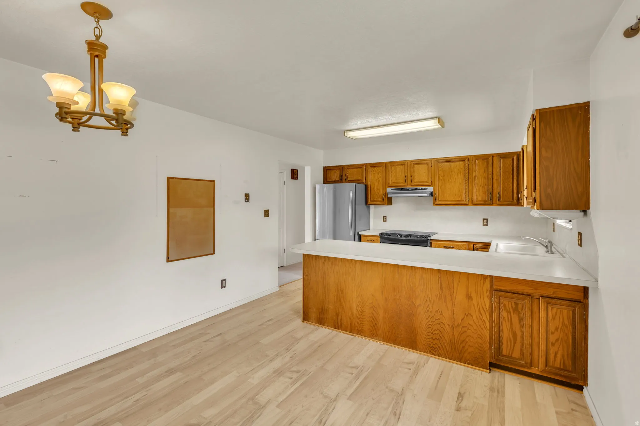 Open-concept kitchen and dining area with wood-finish flooring