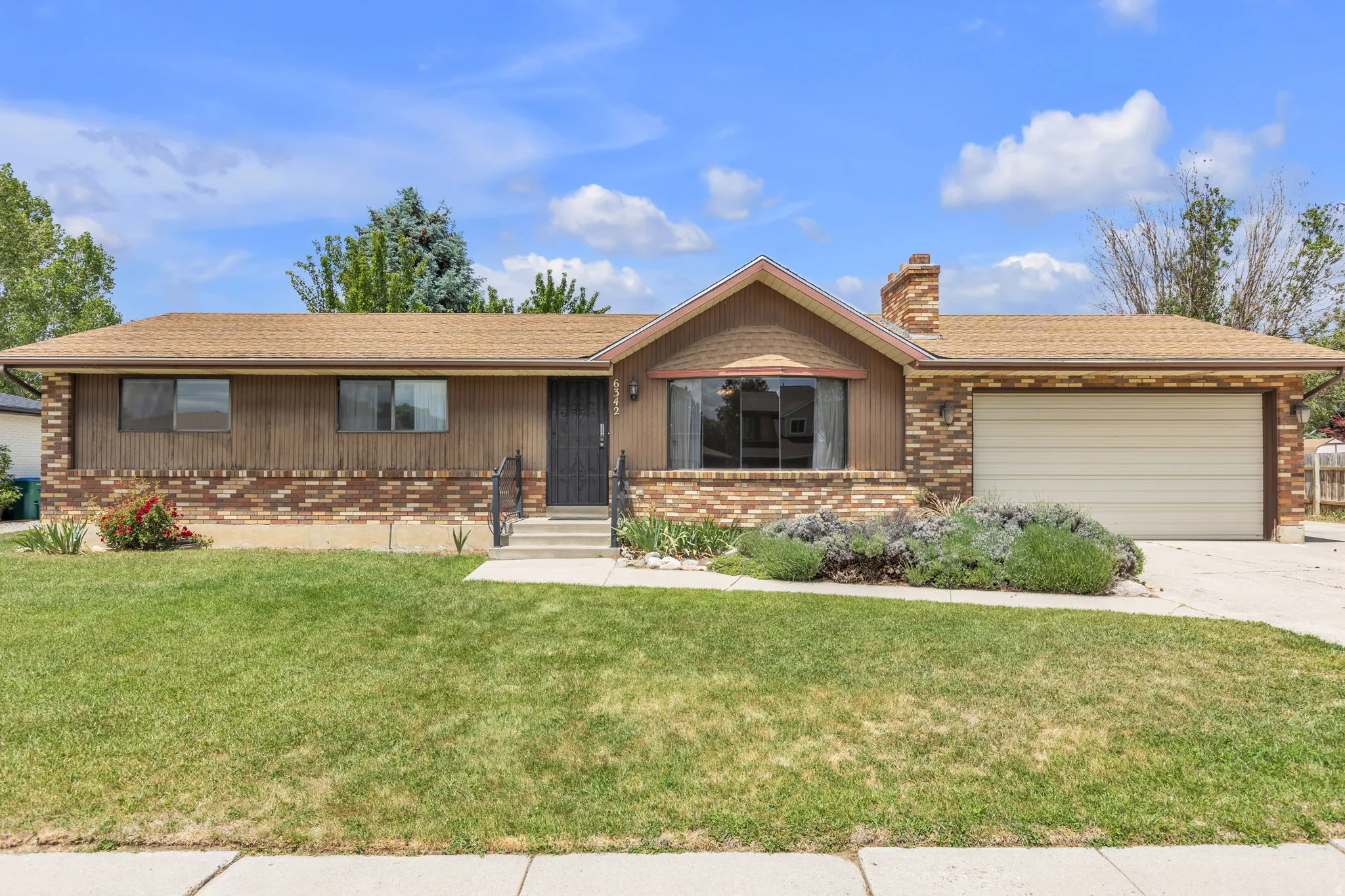 Ranch-style exterior featuring brick and wood paneling