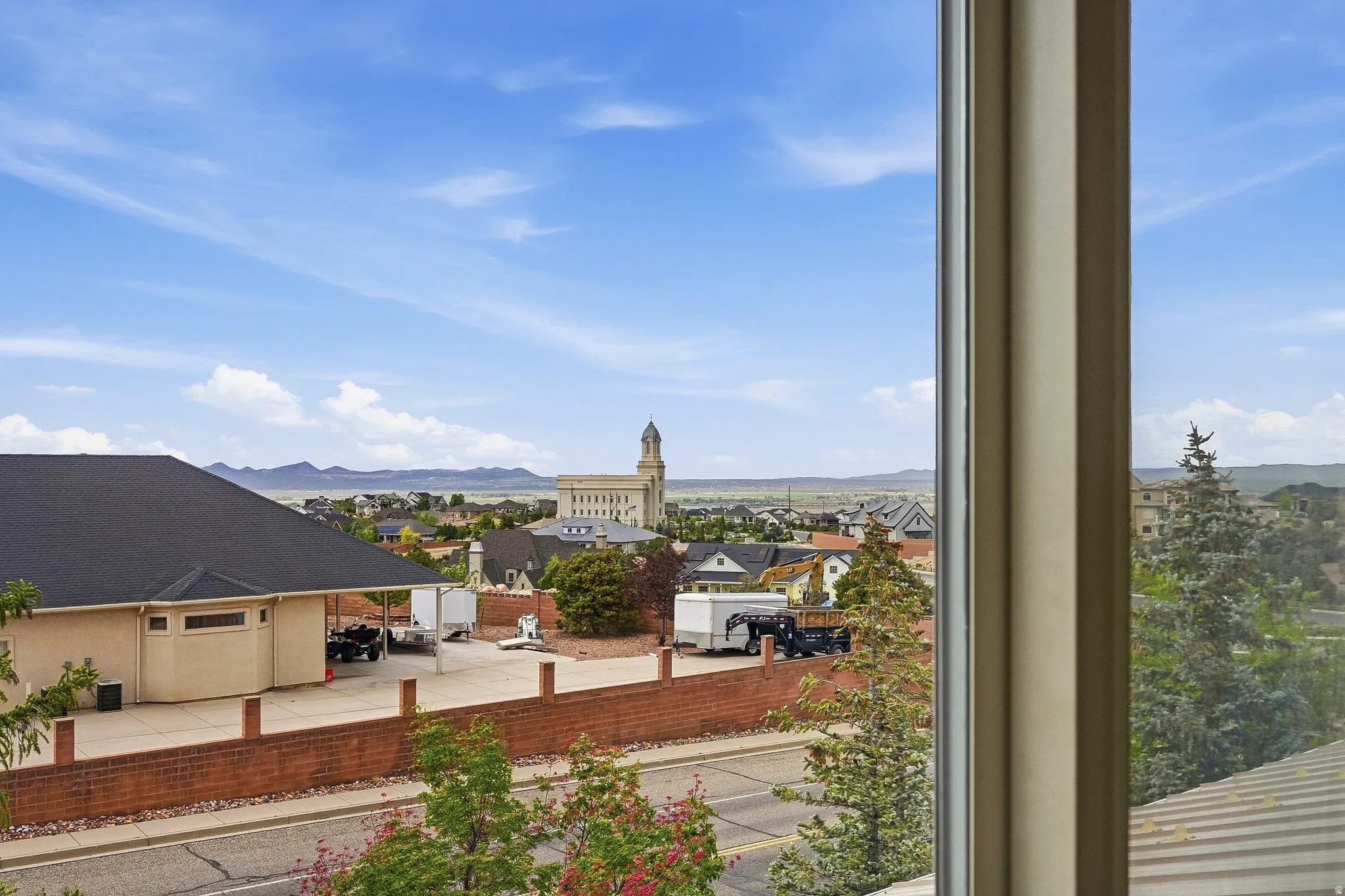 Expansive landscape framed by a window, showcasing distant mountains under a clear sky