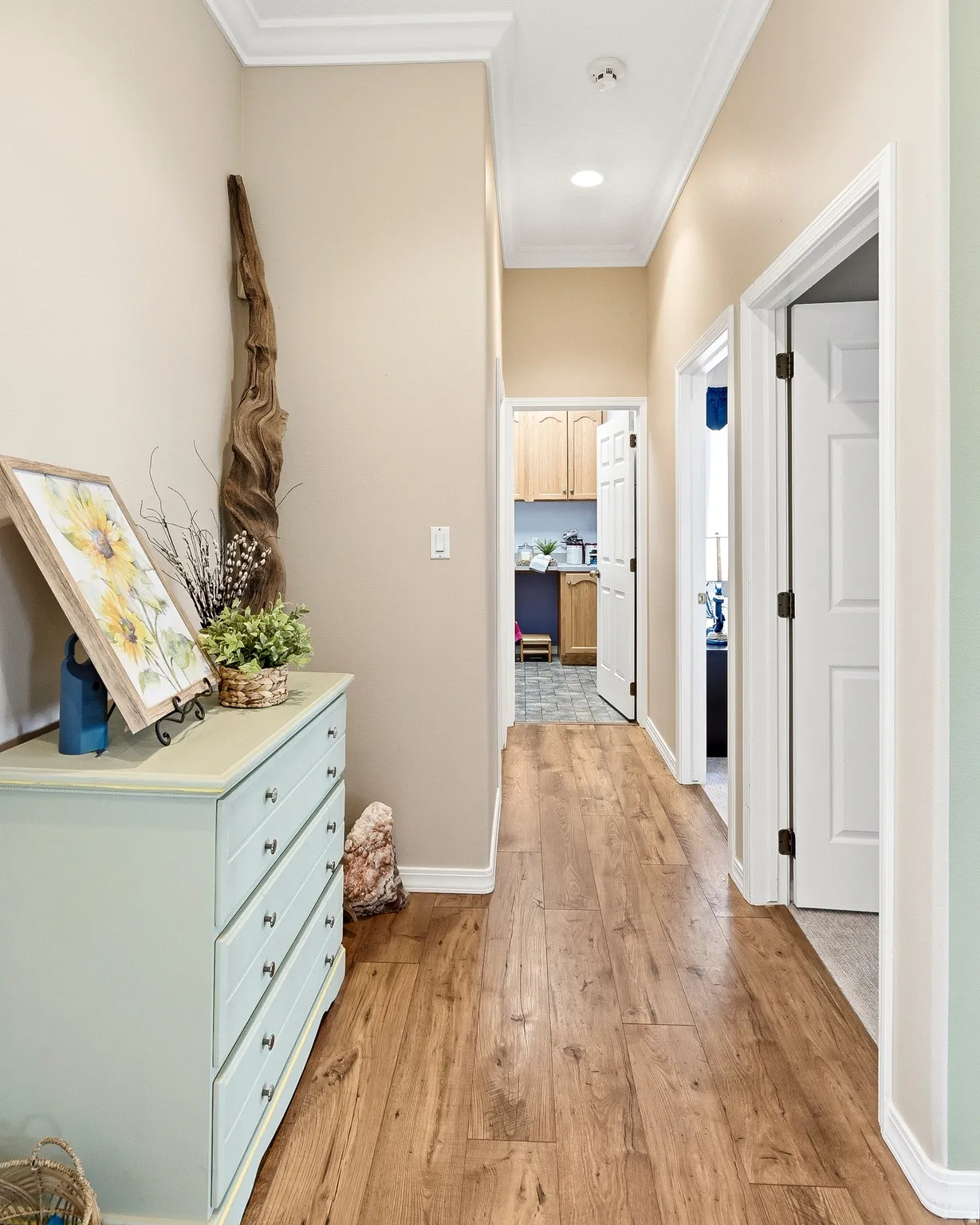Hallway with wood-finish flooring, crown molding, recessed lighting, and white baseboards