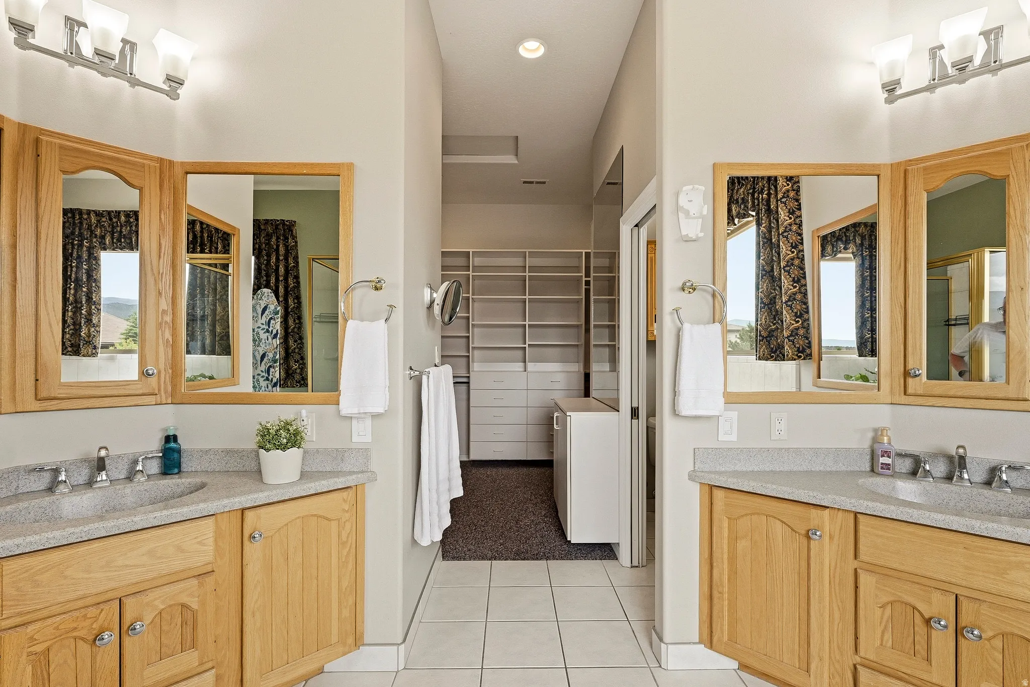 Dual wood-finish vanities with composite countertops and undermount sinks
