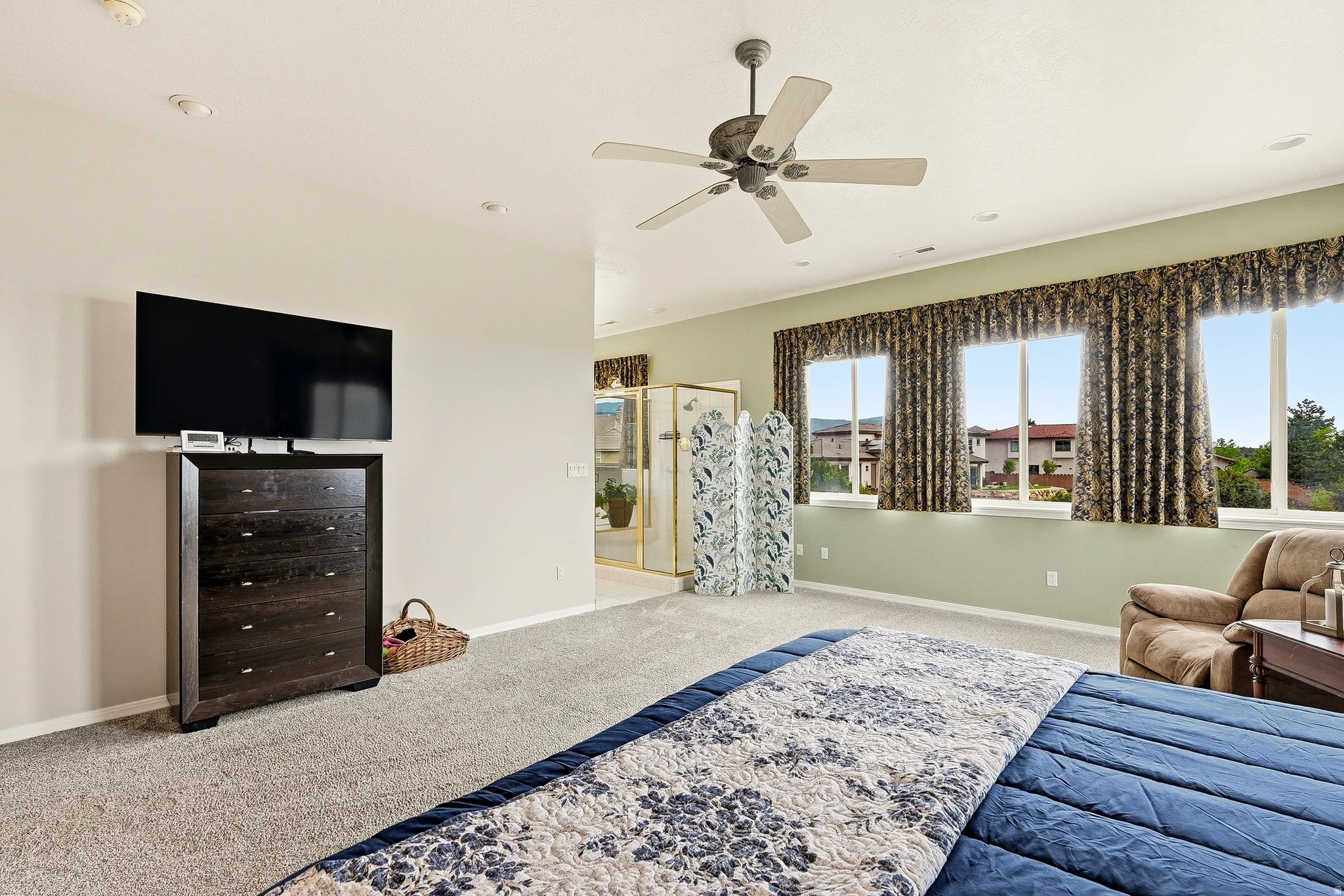 Carpeted room featuring multiple windows with valance and draperies, recessed lighting, and a ceiling fan