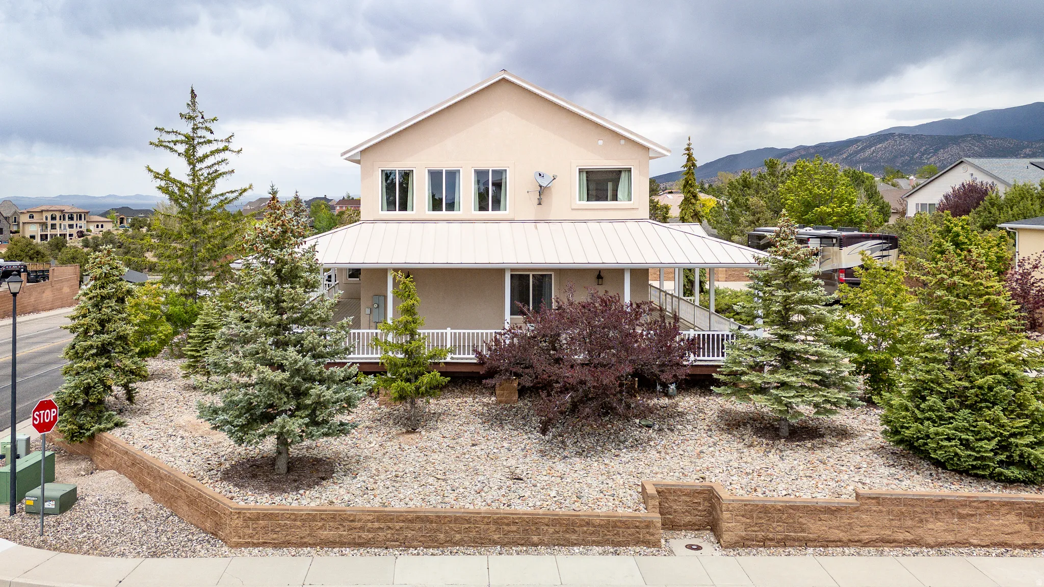 Two-story stucco residence featuring a covered front porch with a white railing