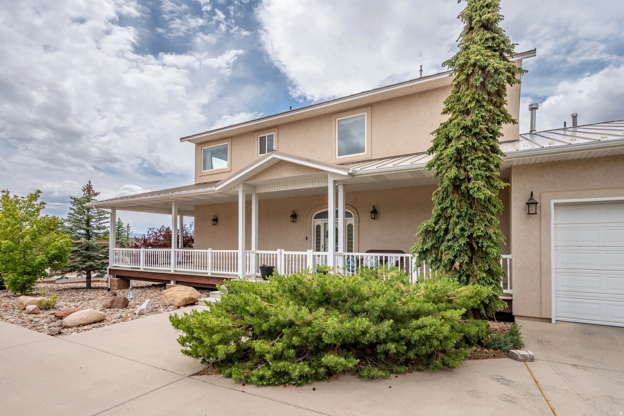 Stucco exterior with a covered porch and white railing