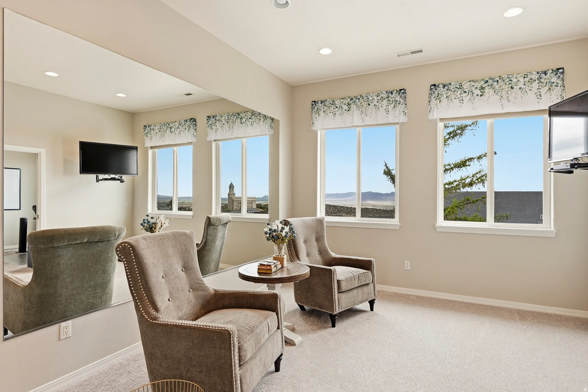 Bright room with multiple windows, recessed lighting, and light-colored carpeting