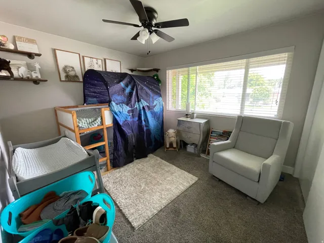 Room featuring a ceiling fan, light gray wall paint, and carpet flooring