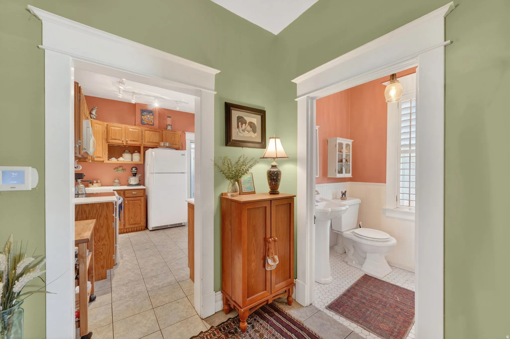 Arched doorways with substantial trim define the entryways to the kitchen and bathroom