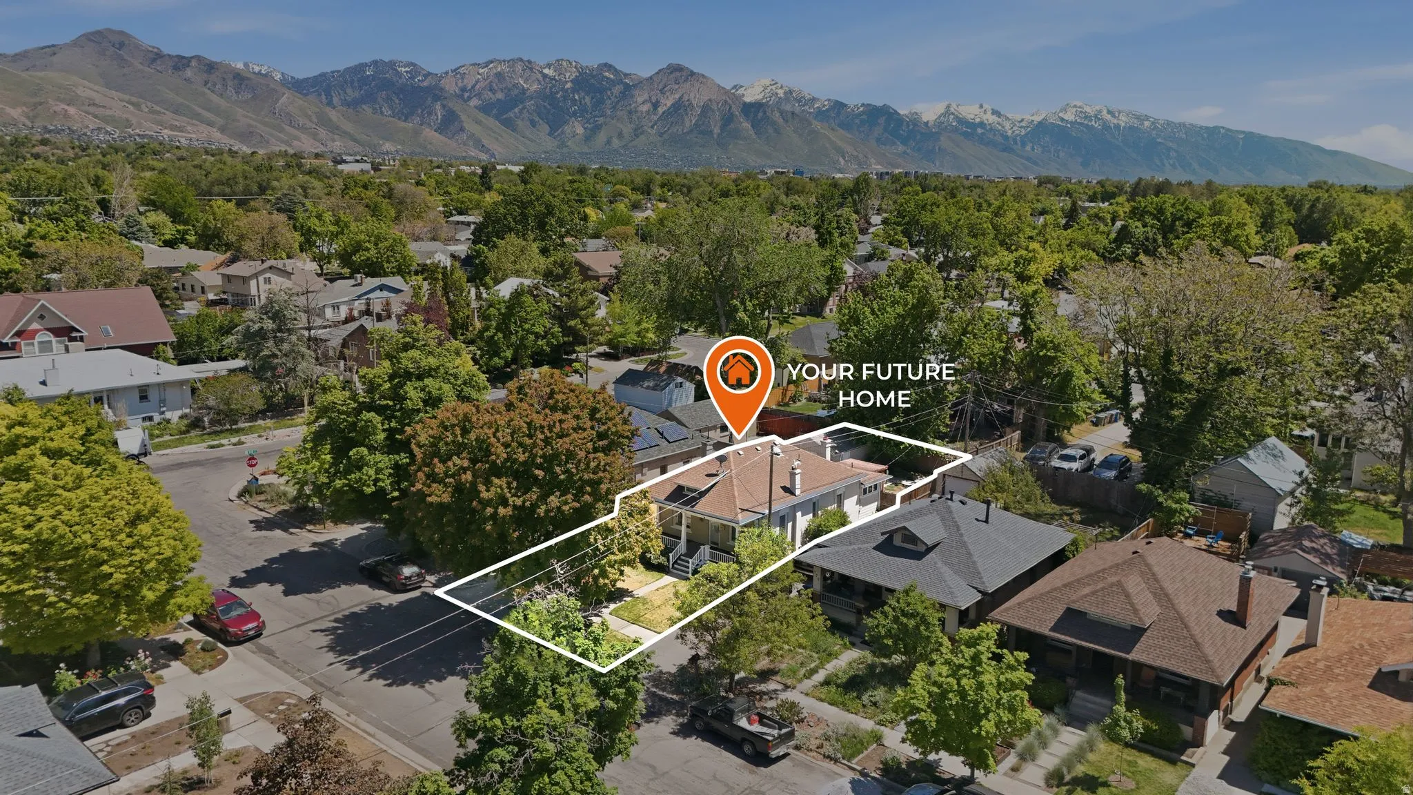 Aerial perspective showcasing a residential property with a distinctive roofline and surrounding mature trees