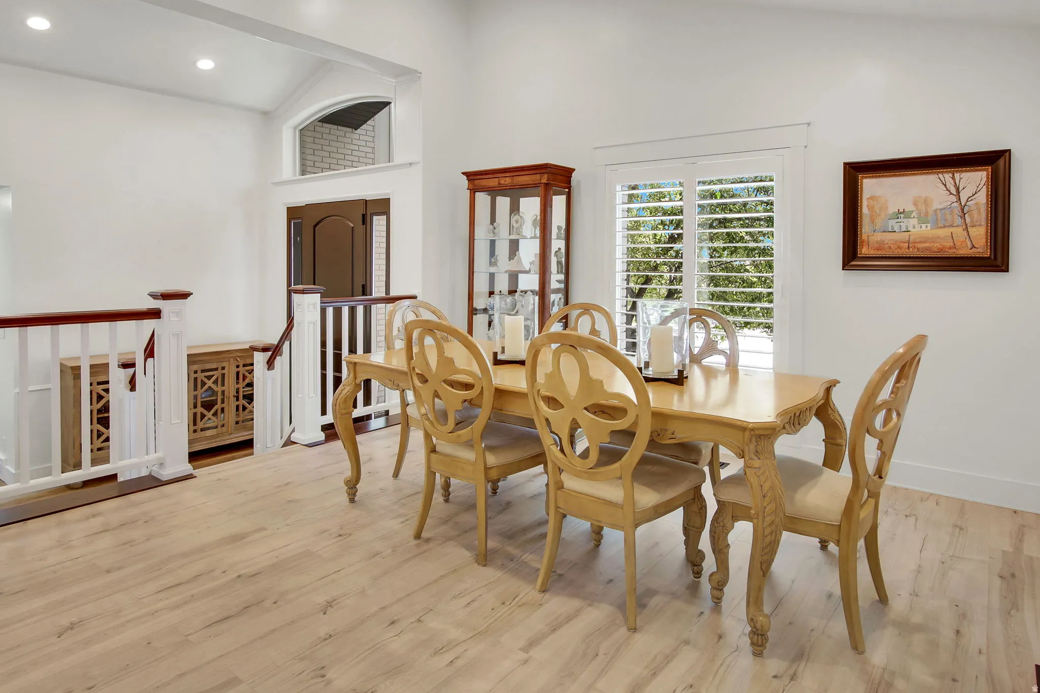 Bright dining area featuring wood-finish flooring and a window with plantation shutters
