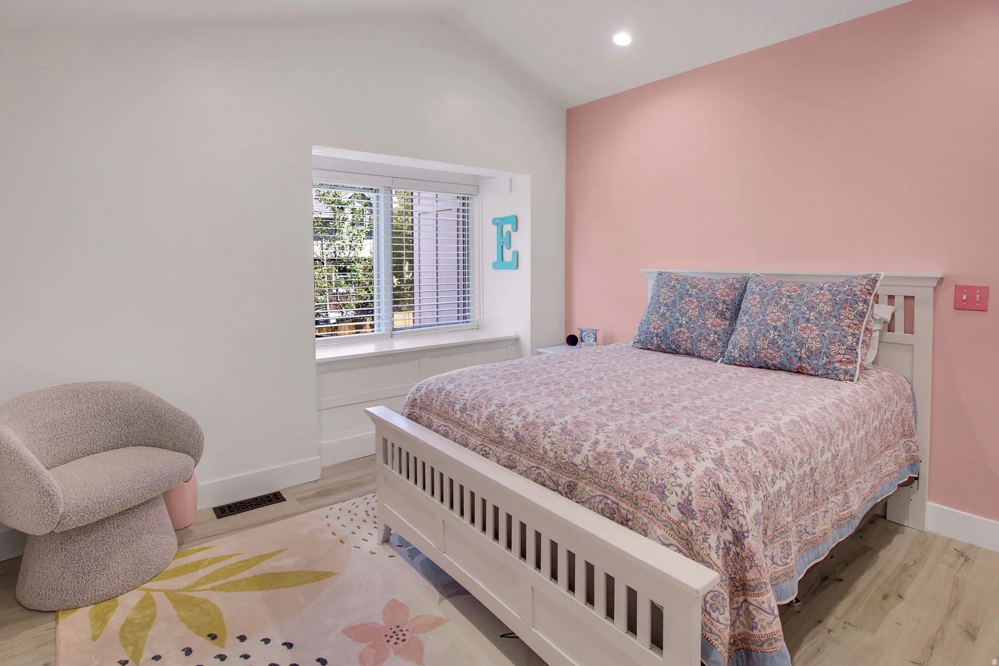 Bedroom featuring a vaulted ceiling and a recessed window with blinds