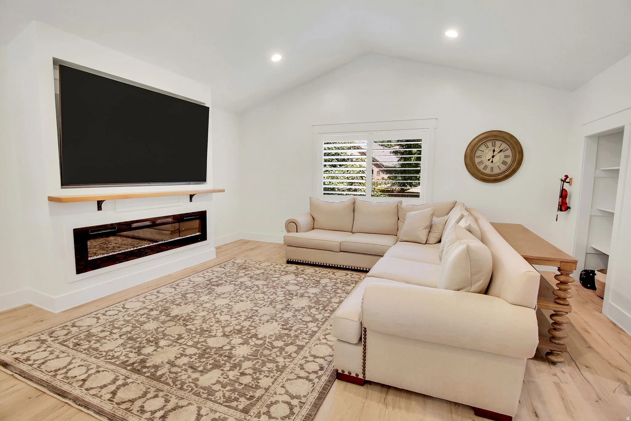 Living area featuring an integrated media wall with a wide screen and linear electric fireplace