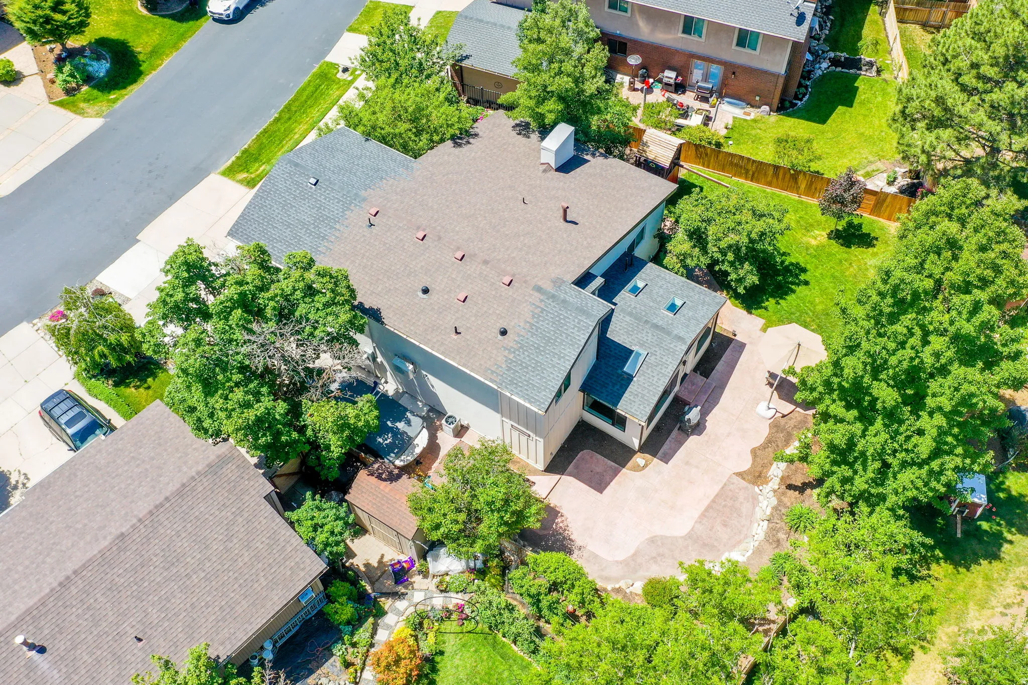 Expansive property featuring a multi-level roofline, skylights, and a patterned concrete patio