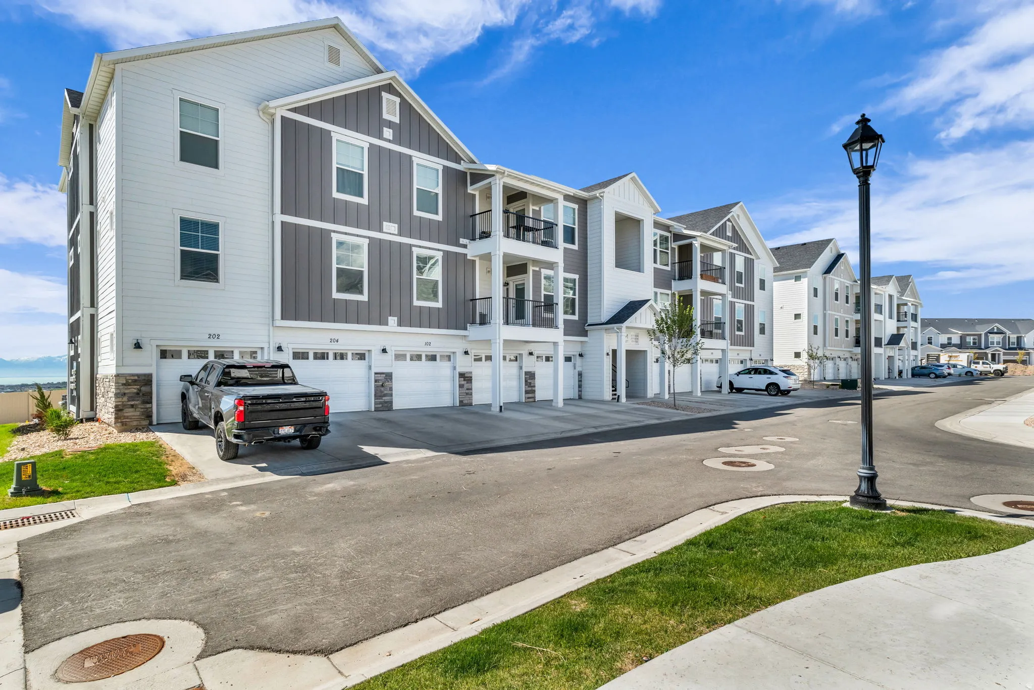 Contemporary townhome-style residences featuring multi-story facades with varied siding, private balconies, and integrated garages